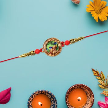 Traditional Krishna Rakhi With Peacock Feather Design And Decorative Beads On Red Thread Wukusy