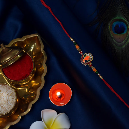 Golden Ganesha Rakhi With Red-green Beads And Stone Detailing Wukusy