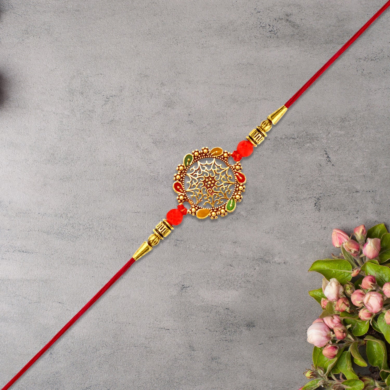 Intricately Designed Circular Rakhi With Multicolor Accents And Red Thread For Rakshabandhan Wukusy