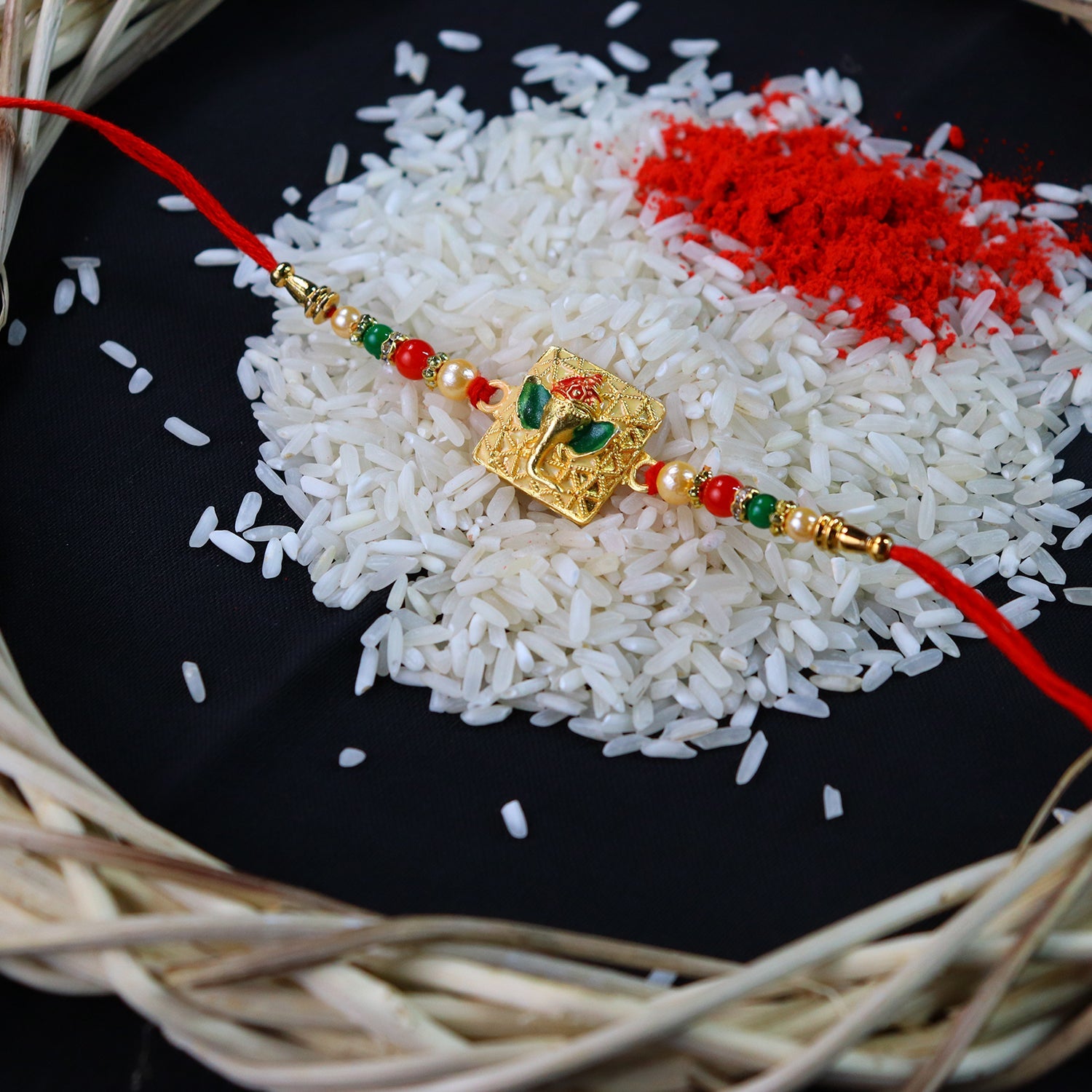 Golden Ganpati Rakhi With Red-green Beads And Enamel Detailing Wukusy