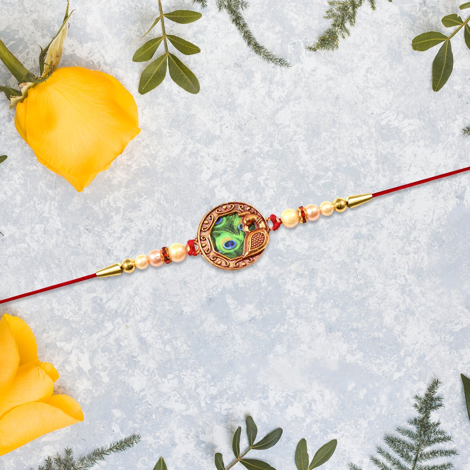 Elegant Rakhi With Peacock Feather Design And Pearl Bead Accents On Red Thread Wukusy